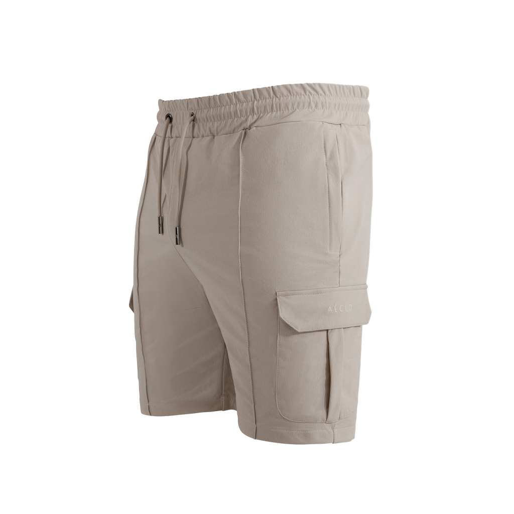 Side profile of beige cargo shorts with tonal embroidery and flap pockets