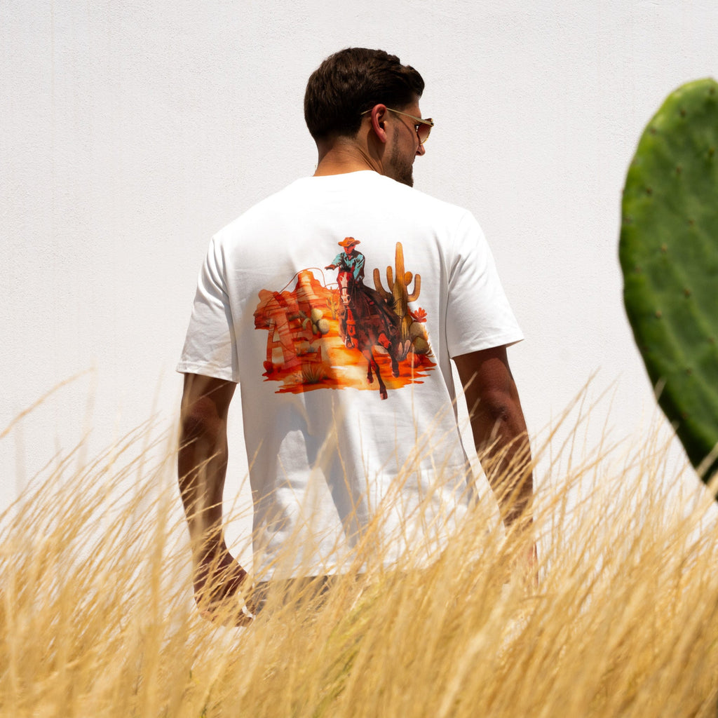 Male model wearing relaxed-fit cowboy tee with large graphic on back, AÉCLO logo front